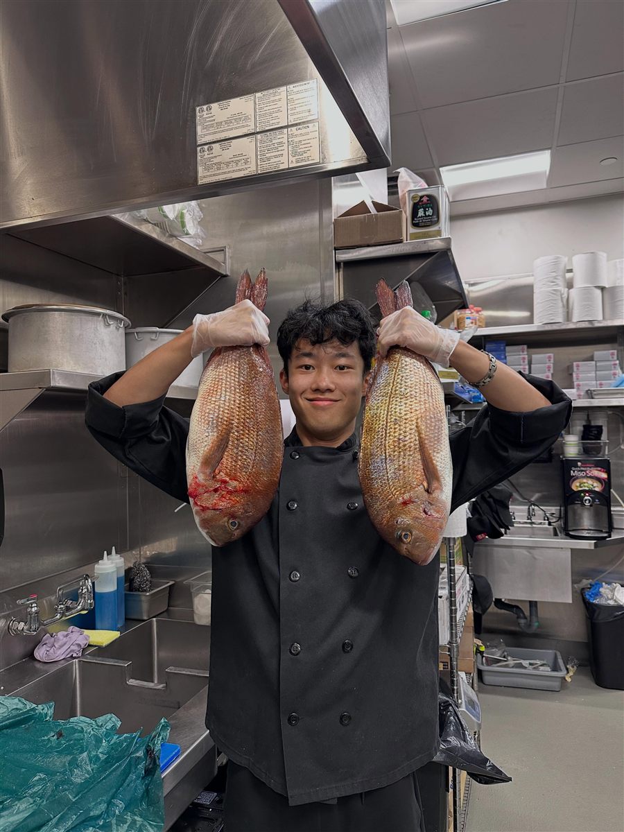 Holding two whole snapper in the kitchen — from my Instagram